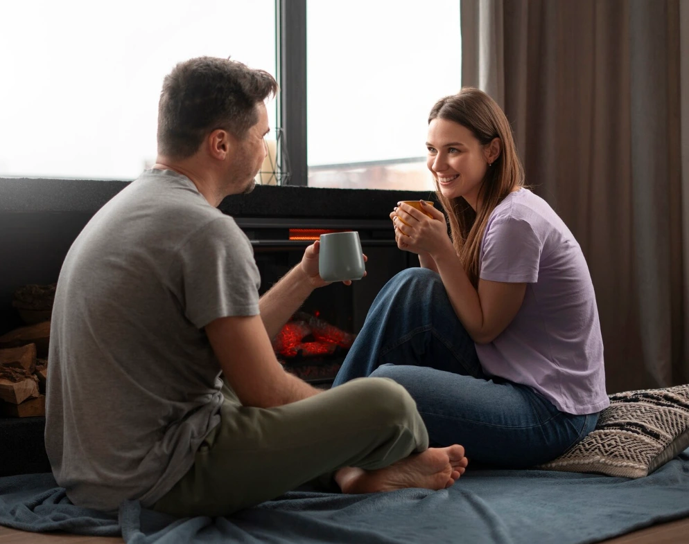 A couple sitting and talking on the floor.