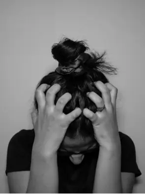 A woman covering her face with her hands