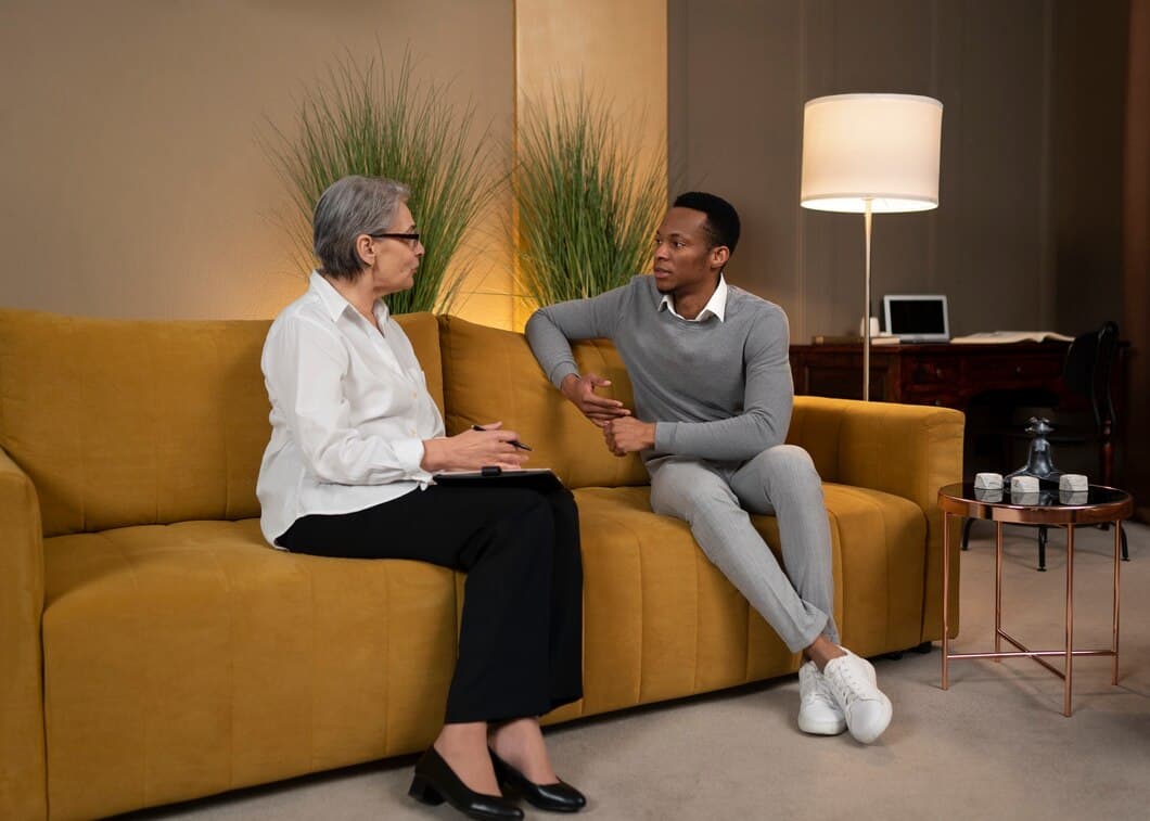 A woman speaking with a licensed therapist in a comfortable, professional setting.