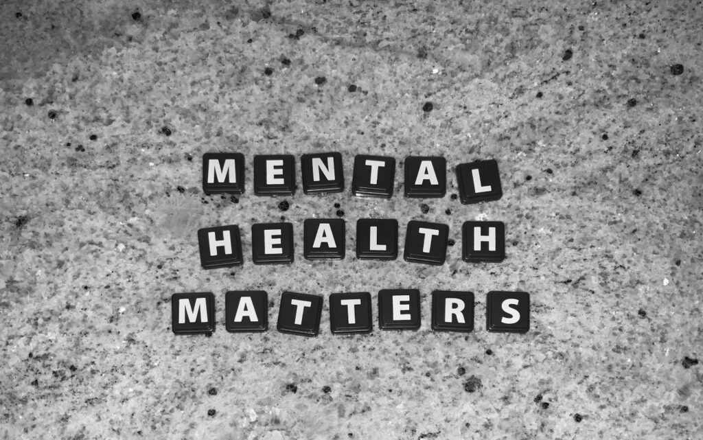 Letter blocks in black and white spell out MENTAL HEALTH MATTERS on a speckled grey granite surface