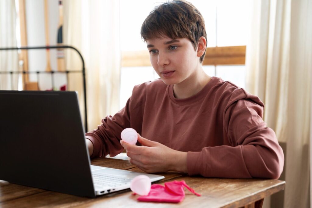 A teenage boy speaking to a therapist on a video call from his room.