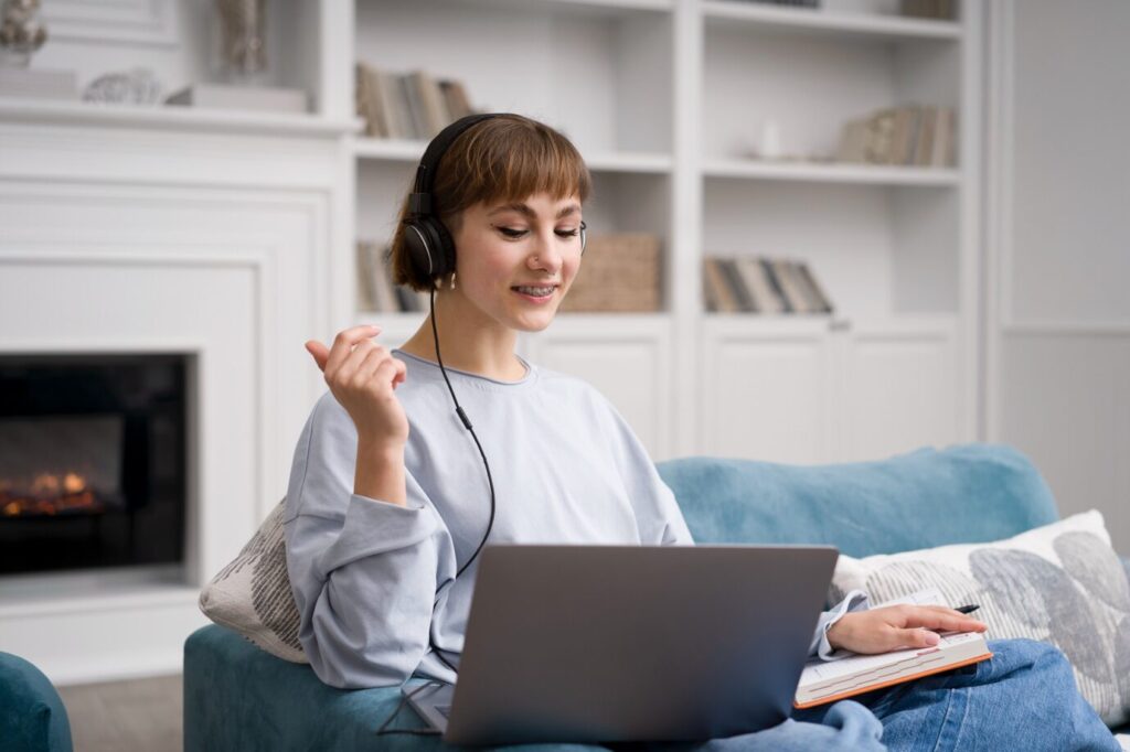 A young woman talks to her therapist on a laptop during an online mental health session.