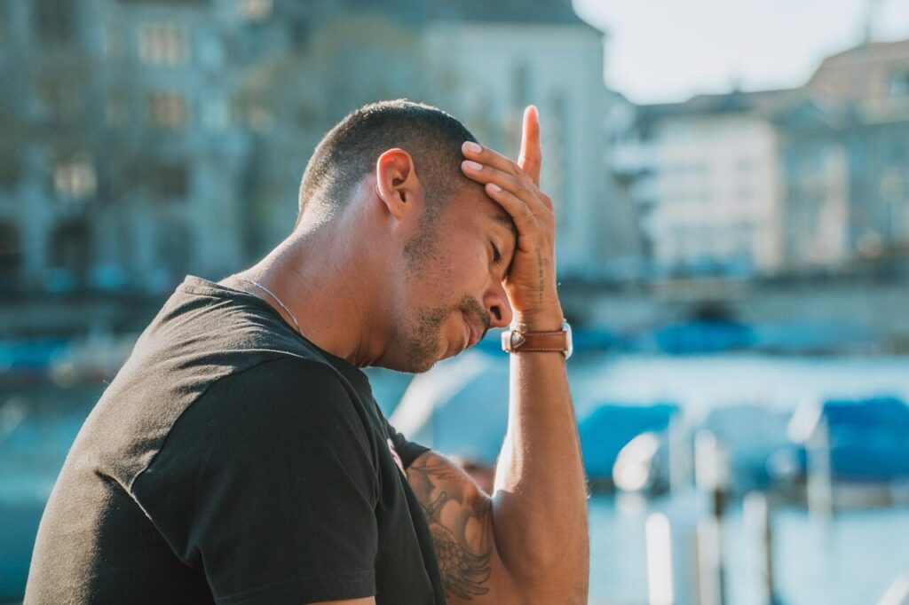 An image of a man holding his head, looking stressed and tired