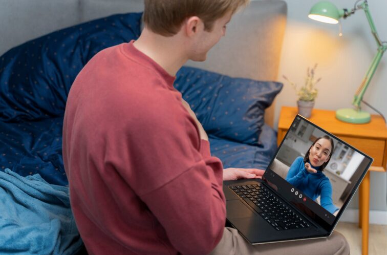 A man engaging in a private video therapy session from his bedroom