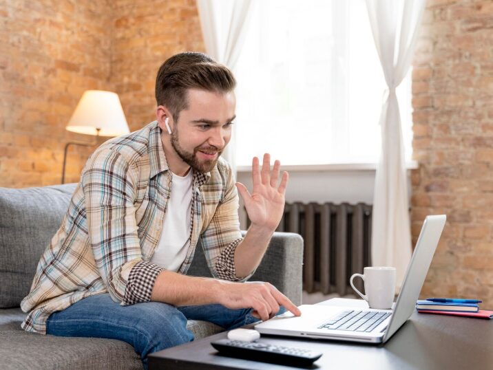 A man smiling and waving during an online therapy session in Corona from his living room