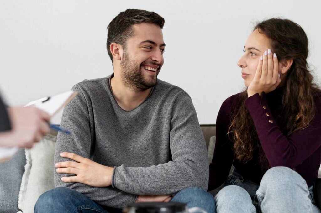 A couple sitting next to each other in a counseling setting in Corona.