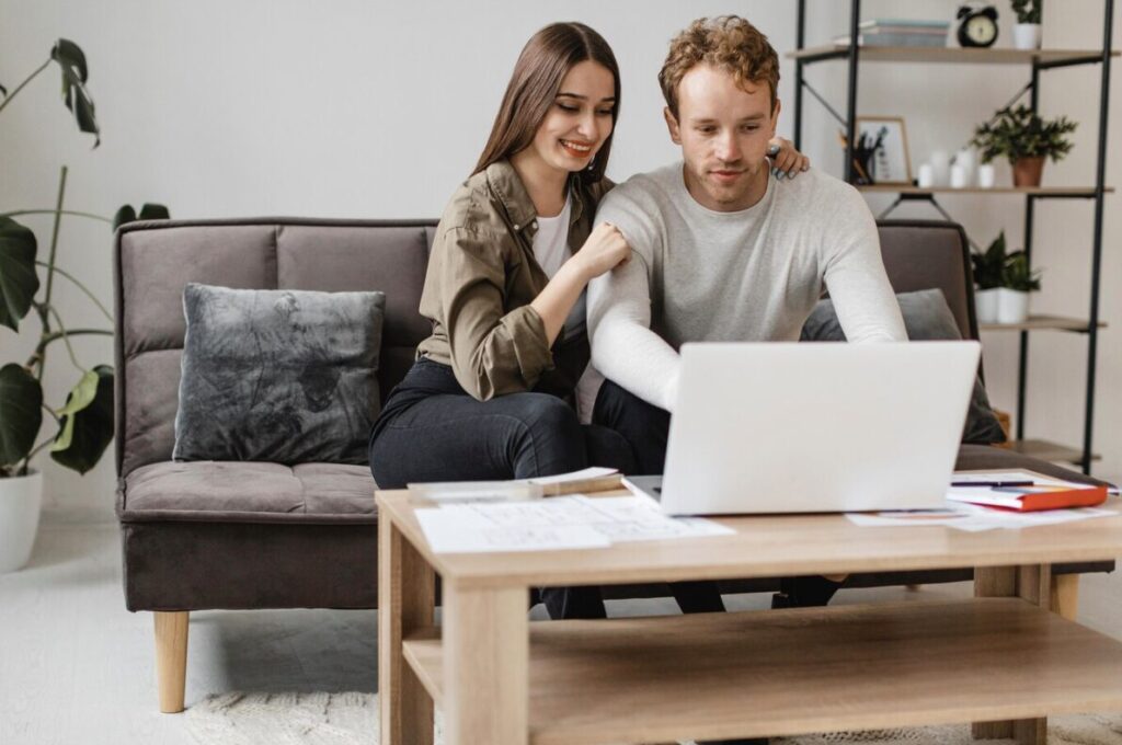 A couple speaking with a virtual pre-marital counselor via a laptop.