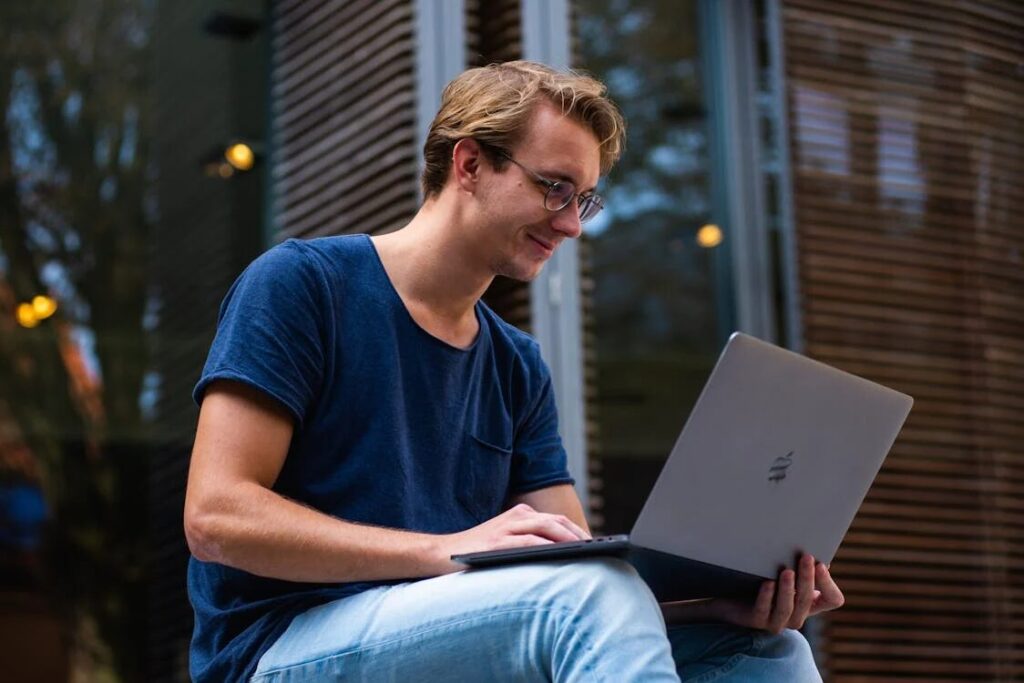 A man speaking with a psychotherapist via a laptop.