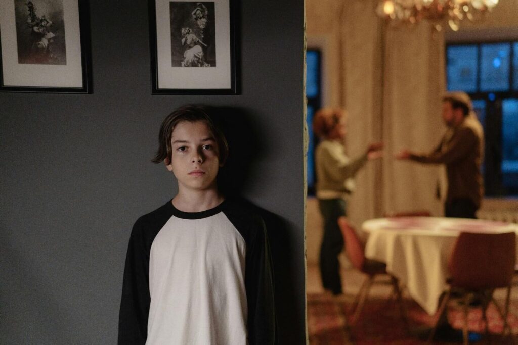 A picture of a boy standing outside the room in which his parents are arguing