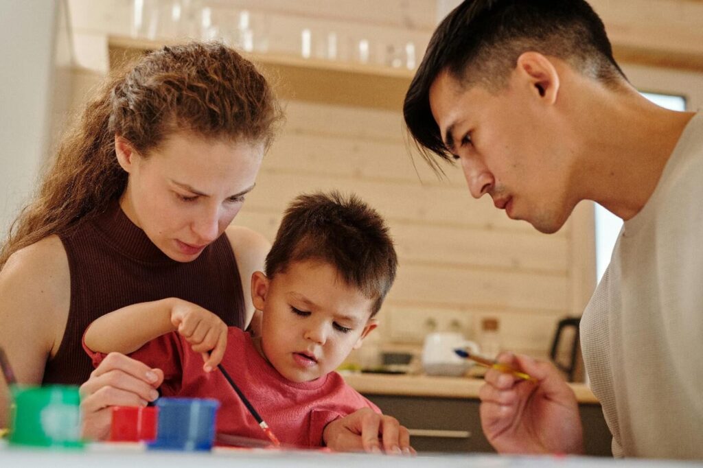 A picture of parents and their child painting together