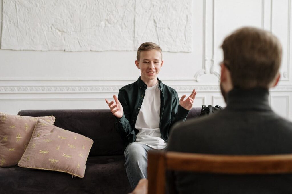 A teenage boy smiling during therapy after recovering from childhood trauma.