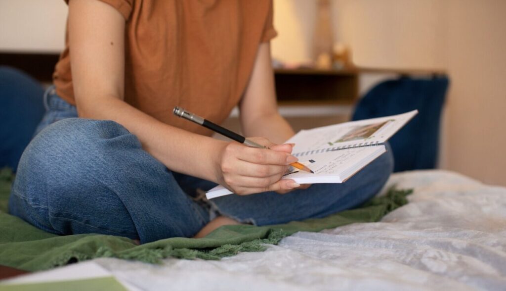 A teenager journaling in a notebook for emotional clarity.