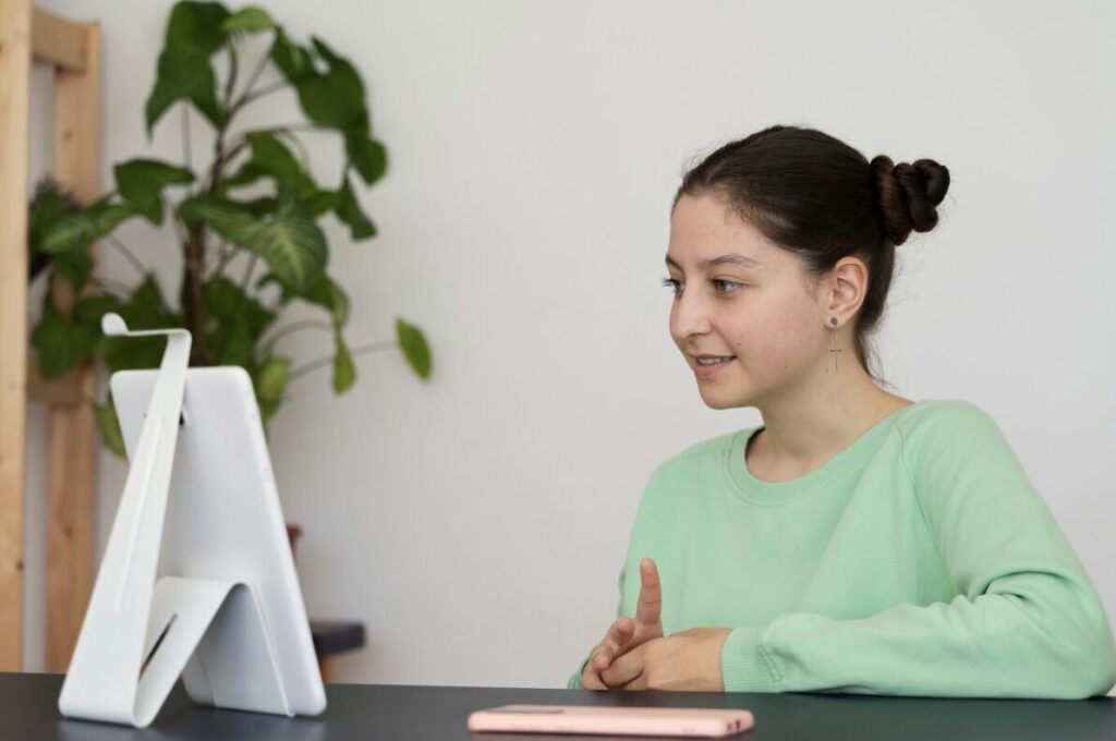 A teenager speaking with a therapist during an online session.