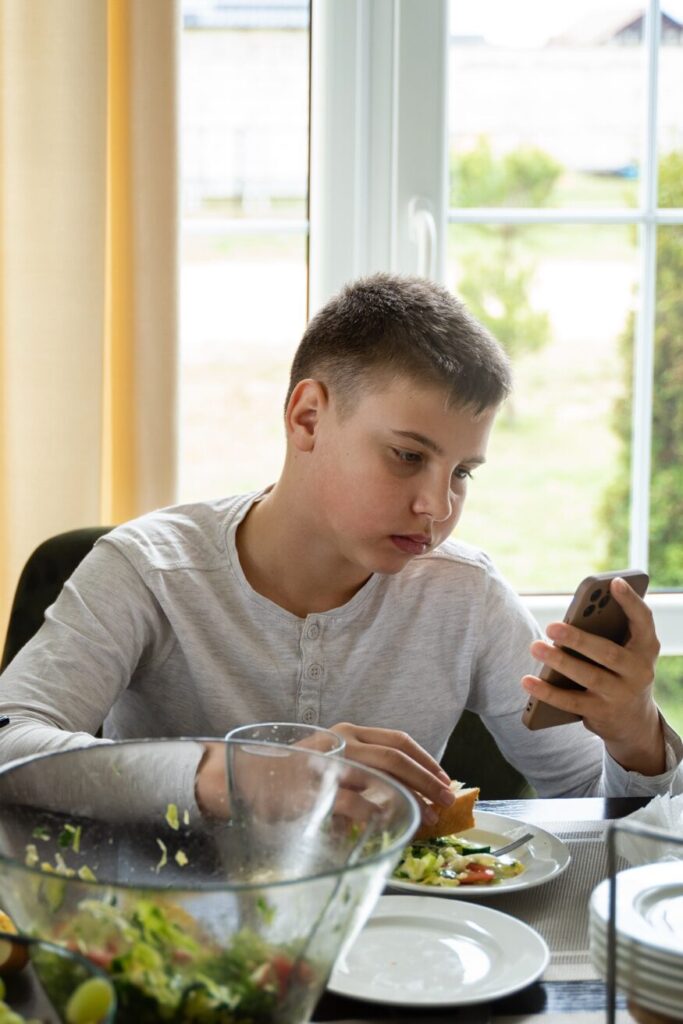 A teenager with an eating disorder sitting at a table.