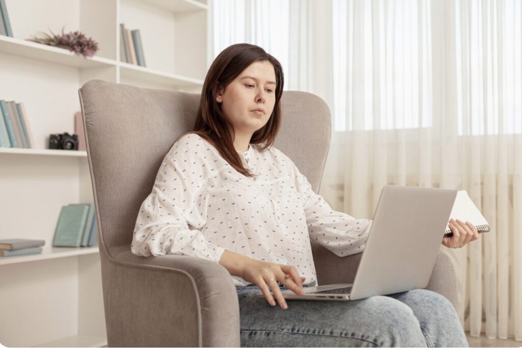 A woman trying deep breathing exercises during an online therapy session.
