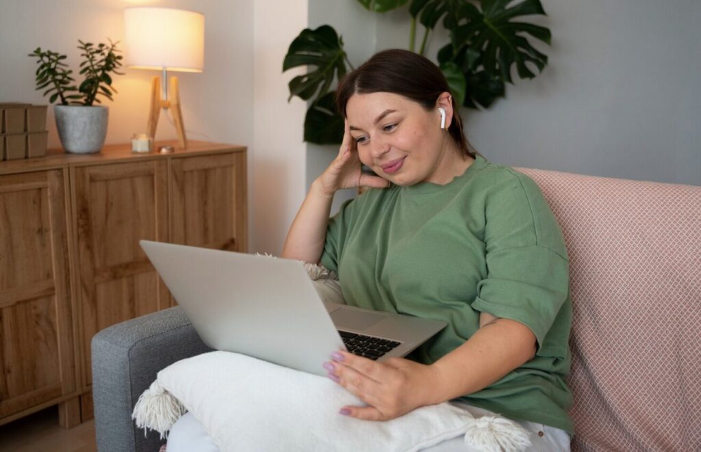 A young woman speaking with her online therapist via a laptop, appearing thoughtful and inspired.