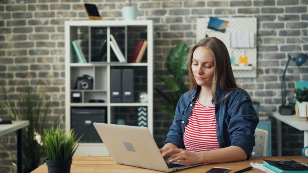 Young woman sitting at a desk during an online session on her laptop.
